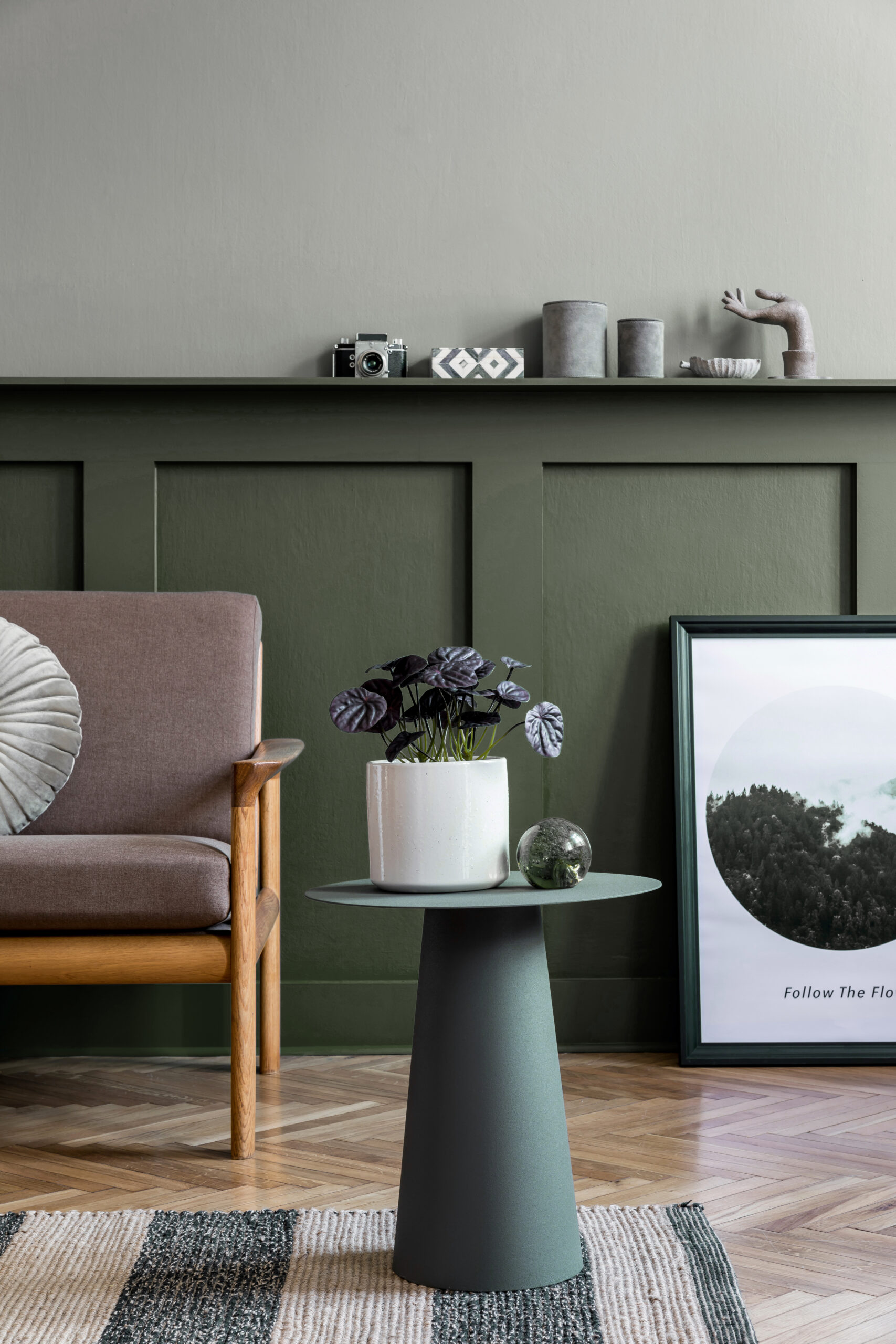 Stylish interior design of living room at cozy apartment with stylish sofa, plants, design furnitures, decoration and elegant accessories. Mock up poster frames on the shelf.  Home staging.