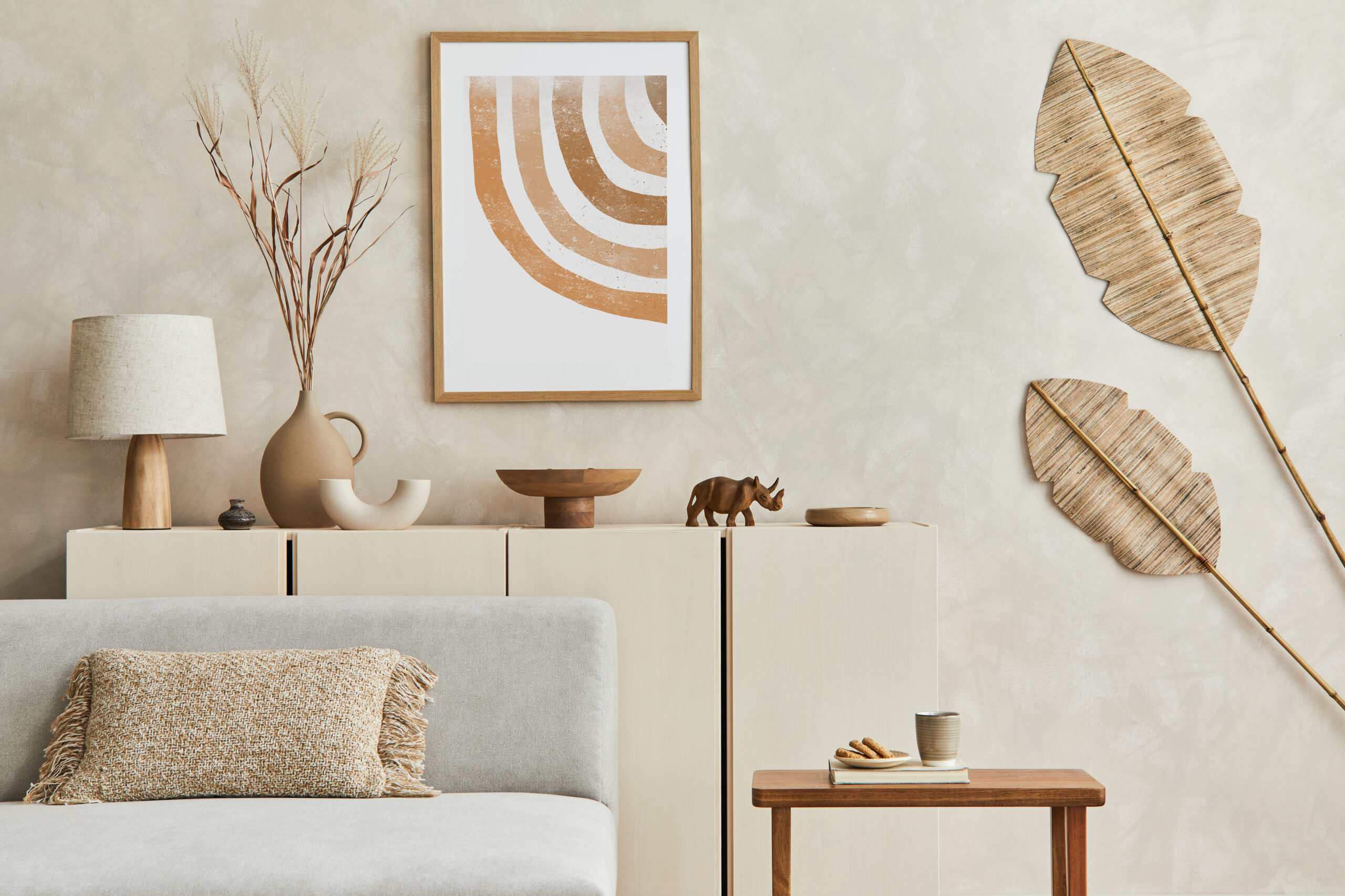 Stylish living room composiiton with mock up poster frame, grey sofa, wooden furnitutre and personal accessories. Pastel neutral colours. Template.
